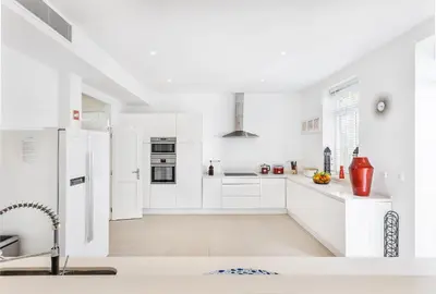 a white kitchen with white counters and appliances at Villa Isabella by OCvillas in Paderne