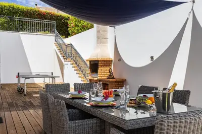 a table and chairs with a table and a fireplace at Villa Isabella by OCvillas in Paderne