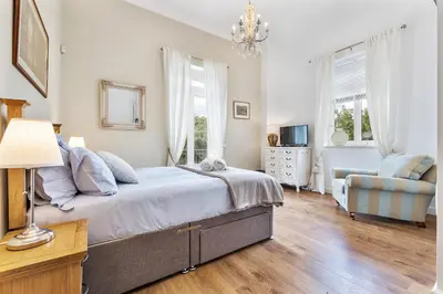 a bedroom with a bed and a couch and a chair at Villa Isabella by OCvillas in Paderne