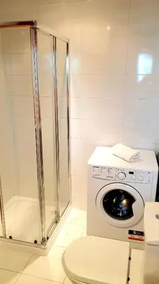 a bathroom with a washing machine and a shower at Apartment São Rafael 63 - Beach - Pool - Free wi-fi - Air Con in Albufeira