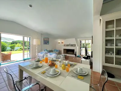 a kitchen and living room with a table and chairs at Albufeira Balaia Villa With Private Pool by Homing in Albufeira