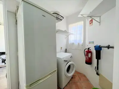a bathroom with a washing machine and a refrigerator at Albufeira Balaia Villa With Private Pool by Homing in Albufeira