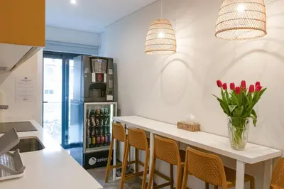 a kitchen with a counter with chairs and a refrigerator at Avenue 41 Guest House in Faro