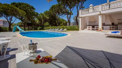 a backyard with a swimming pool and a house at Portuguese mansion close to marina, golf and beach. in Vilamoura