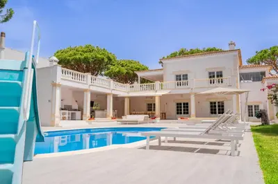 a villa with a swimming pool and a house at Portuguese mansion close to marina, golf and beach. in Vilamoura