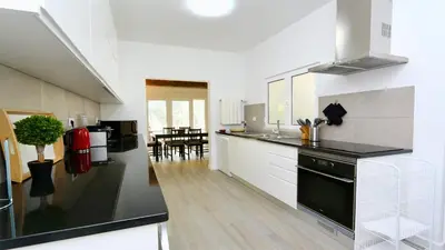 a kitchen with white cabinets and a black counter top at Vila Renascer-CleverDetails, few minutes from the center, quiet area in Vilamoura