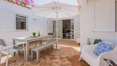 a patio with a table and an umbrella at Sea 3BDR House W/ Patio by Lovelystay in Albufeira