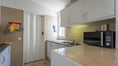 a kitchen with a sink and a microwave at Sea 3BDR House W/ Patio by Lovelystay in Albufeira