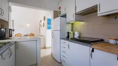 a kitchen with white appliances and white cabinets at Sea 3BDR House W/ Patio by Lovelystay in Albufeira