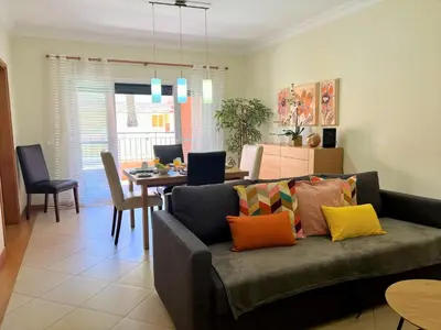 a living room with a couch and a dining room at Vilamoura Victoria Gardens With Pool by Homing in Vilamoura