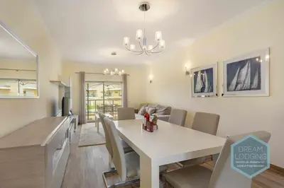 a dining room and living room with a table and chairs at Jardins da Marina - Dream Lodging in Albufeira
