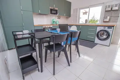 a kitchen with a table and chairs and a washing machine at Apartment close to golf, beaches, Quinta Lago, Vale Lobo, Quarteira and Vilamoura in Quinta do Lago