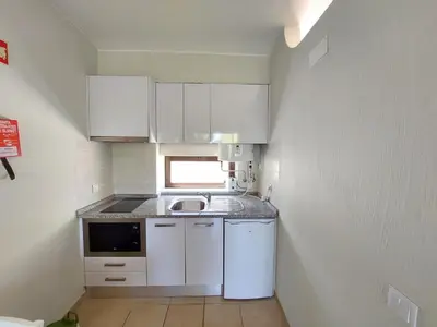 a small kitchen with white cabinets and a sink at A CASA da PRAIA ALBUFEIRA PORTUGAL in Albufeira