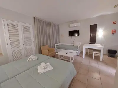 a hotel room with two beds and a table at A CASA da PRAIA ALBUFEIRA PORTUGAL in Albufeira