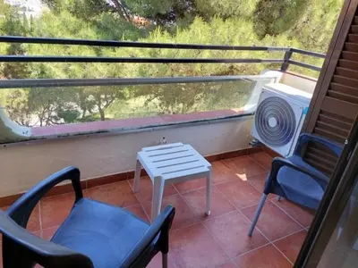 a balcony with two chairs and a table and a heater at A CASA da PRAIA ALBUFEIRA PORTUGAL in Albufeira