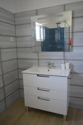 a white bathroom with a sink and a mirror at Apartamento Azul in Quarteira