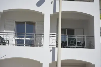 a building with a balcony with a table and chairs at Apartamento Azul in Quarteira
