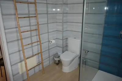 a bathroom with a toilet and a glass shower door at Apartamento Azul in Quarteira