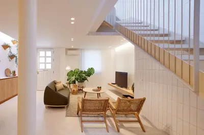 a living room with a staircase and a table and chairs at Bougainvillea 33 by My Cozy Home in Faro