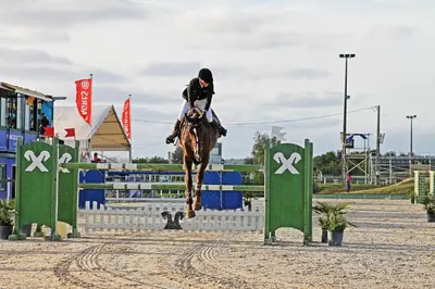 a person riding a horse jumping over an obstacle at Medusa Luxury Marina in Vilamoura