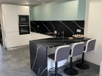 a kitchen with a black counter and white cabinets at Scarlet's Place - 1 bed Victory Village Quinta Do Lago - beach, nature, lakes in Quinta do Lago