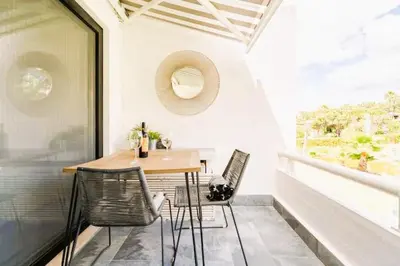 a table and chairs on a balcony with a window at Scarlet's Place - 1 bed Victory Village Quinta Do Lago - beach, nature, lakes in Quinta do Lago