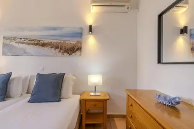 a bedroom with a bed and a desk with a lamp at #014 Mar & Praia Albufeira by Home Holidays in Albufeira