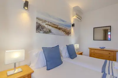 a bedroom with a white bed with blue pillows at #014 Mar & Praia Albufeira by Home Holidays in Albufeira
