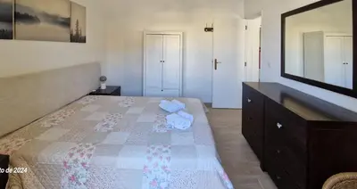 a bedroom with a bed with a dresser and a mirror at Apartamento Solaris T1 - Férias Albufeira in Albufeira