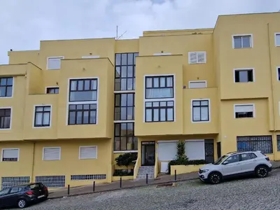 a yellow building with cars parked in front of it at Apartamento Solaris T1 - Férias Albufeira in Albufeira