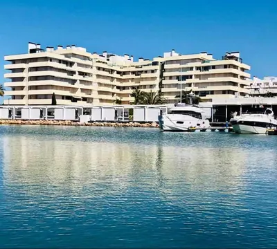 a large building with boats in a body of water at Marina Vilamoura - Aquamar 214 - By Vilamoura Sun in Vilamoura