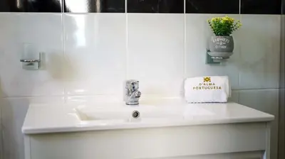 a bathroom sink with a vase of flowers on it at Villa Girassol - By Dalma Portuguesa in Albufeira