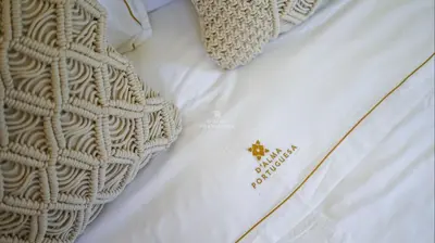 a close up of a white bag on a bed at Villa Girassol - By Dalma Portuguesa in Albufeira
