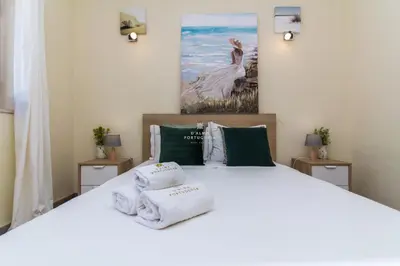 a bedroom with a white bed with towels on it at Villa Girassol - By Dalma Portuguesa in Albufeira