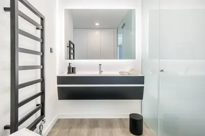 a kitchen with two stools and a counter with black cabinets at Villa Luxueuse Vue Mer in Albufeira