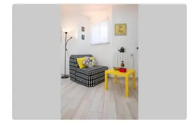 a living room with a chair and a table at BeGuest Casetta Cleo in Páteo