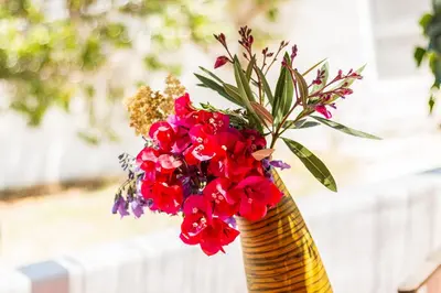 a yellow vase with red flowers in it at Casas Barulho - Villa Jacaranda A8 in Albufeira