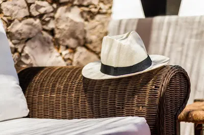 a hat sitting on top of a wicker chair at Casas Barulho - Villa Jacaranda A8 in Albufeira