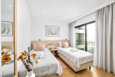 a bedroom with two beds and a mirror at Stylish Modern Beachside Apartment with Pool & Seaview in Quarteira