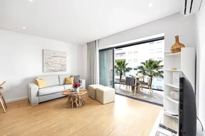 a living room with a couch and a table at Stylish Modern Beachside Apartment with Pool & Seaview in Quarteira