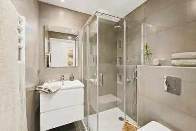 a bathroom with a shower and a toilet and a sink at Stylish Modern Beachside Apartment with Pool & Seaview in Quarteira