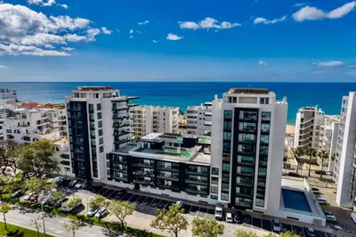 an aerial view of buildings in front of the ocean at Stylish Modern Beachside Apartment with Pool & Seaview in Quarteira