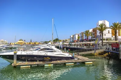 a boat docked at a dock in a marina at Penthouse Escape with Large Terrace, Pool & Garden in Quarteira