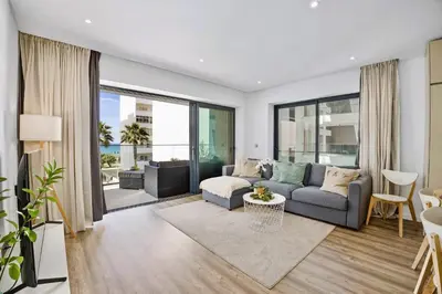 a living room with a couch and a table at Bright Modern Beachside Apartment with Pool & Seaview in Quarteira