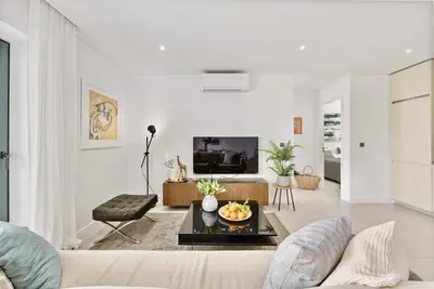 a living room with a couch and a table at 2-Bedroom Beachside Apartment with Pool & Parking in Quarteira