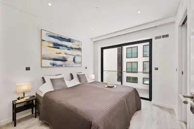 a bedroom with a bed and a large window at 2-Bedroom Beachside Apartment with Pool & Parking in Quarteira