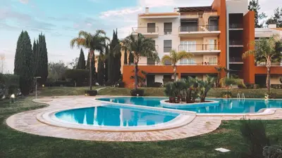 an image of a swimming pool in front of a building at THE PALM at the Palm Village 2 Bedrooms Apartment in Vilamoura