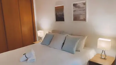 a bedroom with a white bed with two lamps at THE PALM at the Palm Village 2 Bedrooms Apartment in Vilamoura