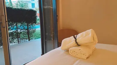 a towel sitting on top of a bed next to a window at THE PALM at the Palm Village 2 Bedrooms Apartment in Vilamoura