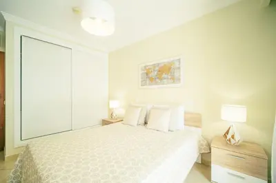 a white bedroom with a bed and two lamps at Albufeira - Cerro Mar Star - Cozy and Relaxing T1 in Albufeira